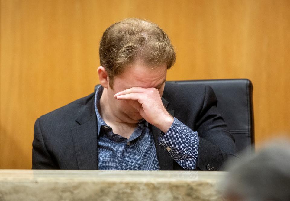 William Henderson, son of David Henderson, reacts to crime scene photos during the trial Monday.