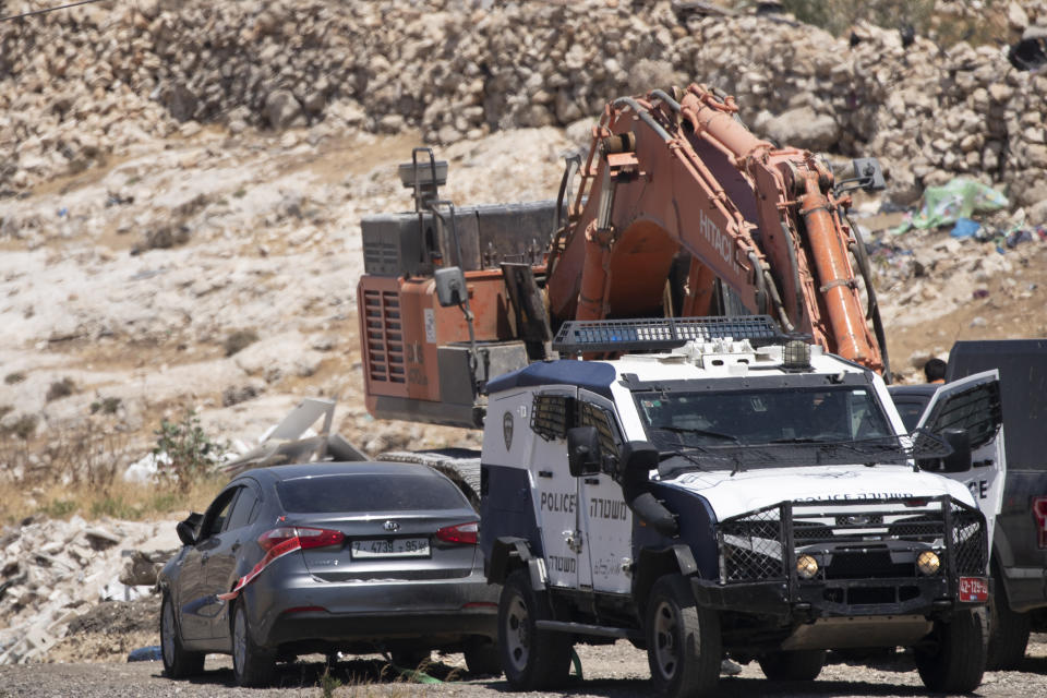 Israeli police tow a car that was said to be used in an attack near Hizmeh Junction in the West Bank, Wednesday, June 16, 2021. The Israeli military on Wednesday shot and killed a Palestinian woman who it said tried to ram her car into a group of soldiers guarding a West Bank construction site. (AP Photo/Maya Alleruzzo)
