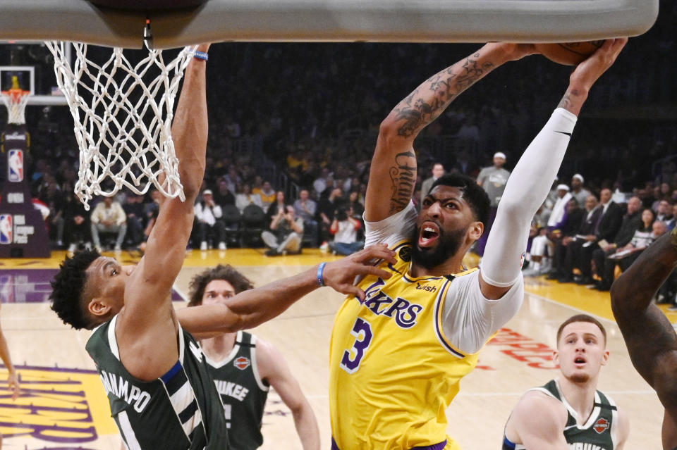 FILE - In this March 6, 2020, file photo, Los Angeles Lakers forward Anthony Davis, right, shoots as Milwaukee Bucks forward Giannis Antetokounmpo defends during the first half of an NBA basketball game in Los Angeles. Davis and the Lakers were leading the Western Conference when the coronavirus pandemic caused the suspension of the NBA season, but he is confident they’ll be able to resume their title chase. (AP Photo/Mark J. Terrill, File)