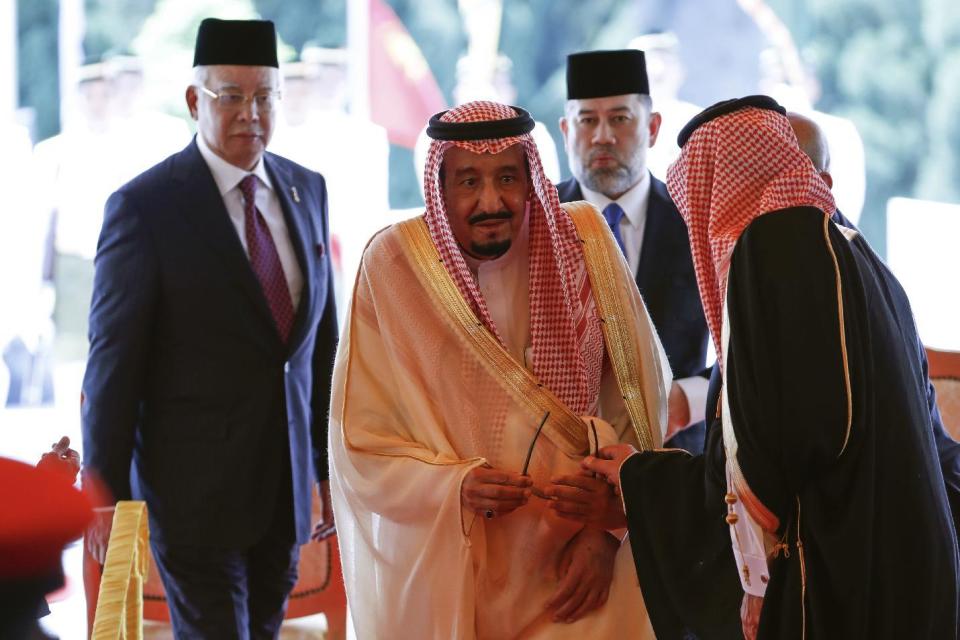 Saudi Arabia's King Salman, center, escorted by Malasia's Prime Minister Najib Razak, left, leaves after inspecting an honor guard during a welcoming ceremony at Parliament House in Kuala Lumpur, Malaysia Sunday, Feb. 26, 2017. Salman on a four-day official visit to Malaysia. (AP Photo/Vincent Thian)