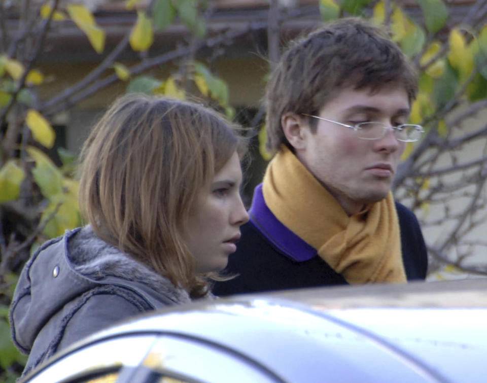 FILE - American exchange student Amanda Knox, left, and her Italian boyfriend Raffaele Sollecito outside the rented house where 21-year-old British student Meredith Kercher was found dead in Perugia, Italy, Nov. 2, 2007. Amanda Knox is expected to appear in person in an Italian court to defend herself in a slander case that has the potential to remove the last legal stain against her, following her exoneration nine years ago in the 2007 murder of her British roommate, Meredith Kercher. (AP Photo/Stefano Medici, File)