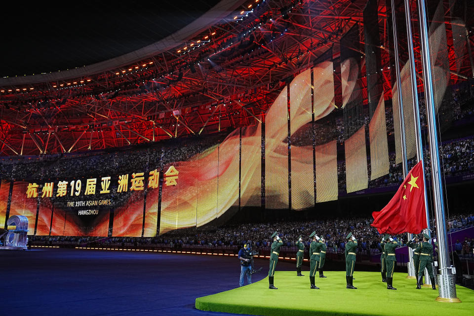 Military soldiers salute as a Chinese flag is raised during the closing ceremony of the 19th Asian Games in Hangzhou, China, Sunday, Oct. 8, 2023. (AP Photo/Vincent Thian)