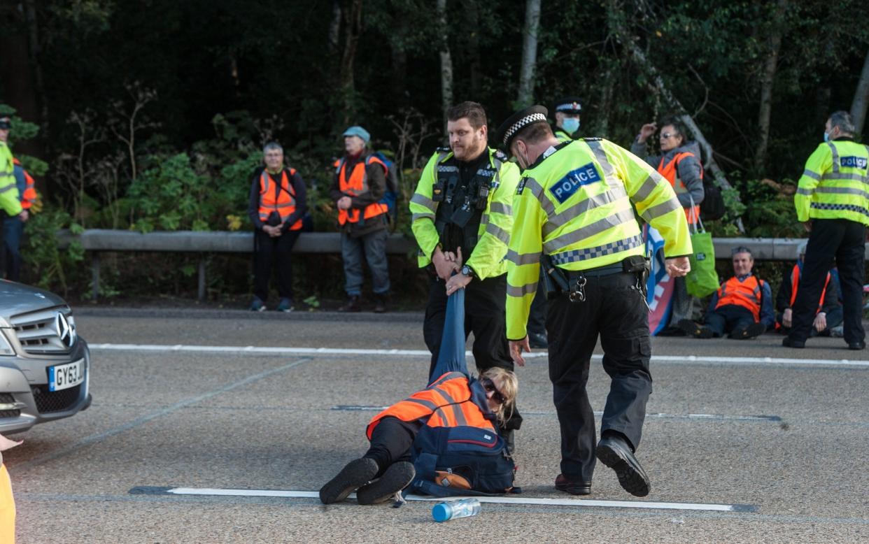 Police remove activists from the motorway as protestors from Insulate Britain block the M25 motorway near Cobham in Surrey on September 21, 2021 - Guy Smallman/Getty Images