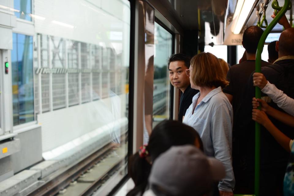 A man looks outside the window of a crowded REM train in Montreal on Saturday, July 29, 2023.