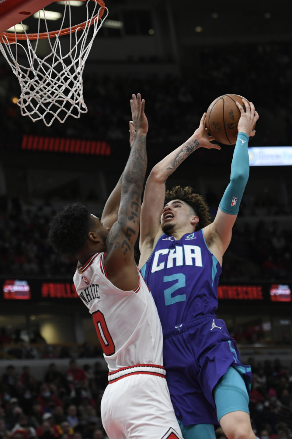 Charlotte Hornets guard LaMelo Ball (2) goes up for a shot against Chicago Bulls guard Coby White (0) during the second half of a NBA basketball game Monday, Nov. 29, 2021 in Chicago. Chicago won 133-119. (AP Photo/Paul Beaty)