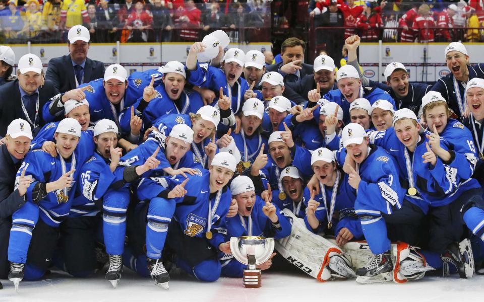 Finland players celebrate with the trophy after they defeated Sweden in overtime of their IIHF World Junior Championship gold medal ice hockey game in Malmo, Sweden, January 5, 2014. REUTERS/Alexander Demianchuk (SWEDEN - Tags: SPORT ICE HOCKEY)