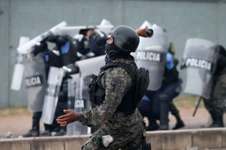 A soldier throws a tear gas canister during a clash with supporters of Salvador Nasralla, presidential candidate for the Opposition Alliance Against the Dictatorship, as they wait for official presidential election results in Tegucigalpa, Honduras, November 30, 2017. REUTERS/Edgard Garrido