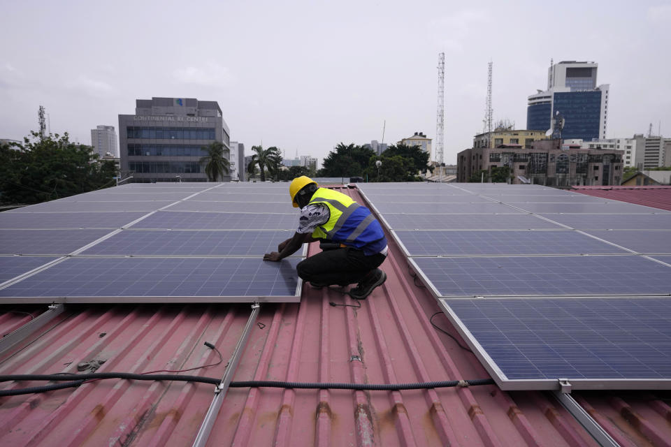 Oladapo Adekunle, an engineer with Rensource Energy, installs solar panels on a roof of a house in Lagos, Nigeria, Thursday, March 21, 2024. Funding for climate tech startups in Africa from the private sector is growing, but there's still a long way to go. (AP Photo/Sunday Alamba)