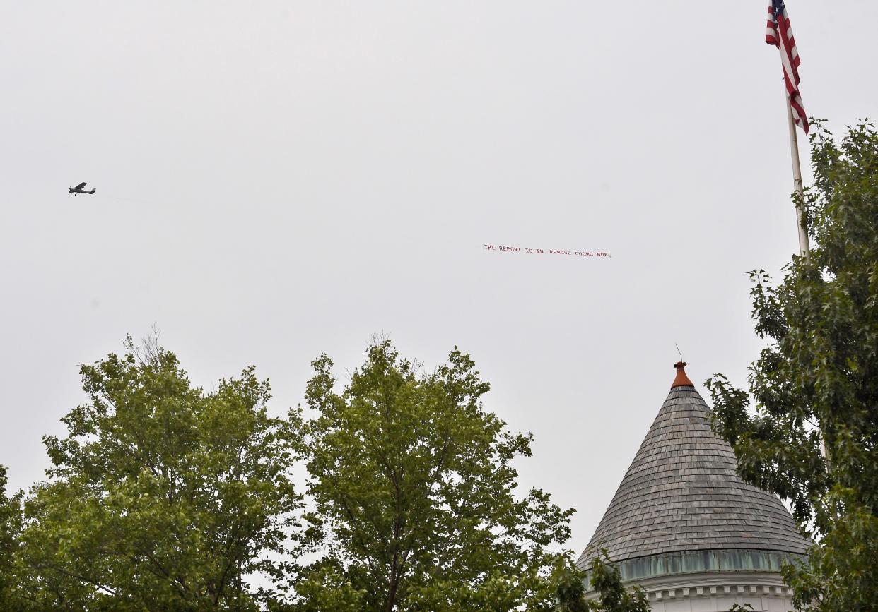 A small airplane flies a banner with the message "The Report is in. Remove Cuomo Now" circles around the Empire State Plaza and the New York state Executive Mansion, Wednesday, Aug. 4, in Albany, N.Y. 