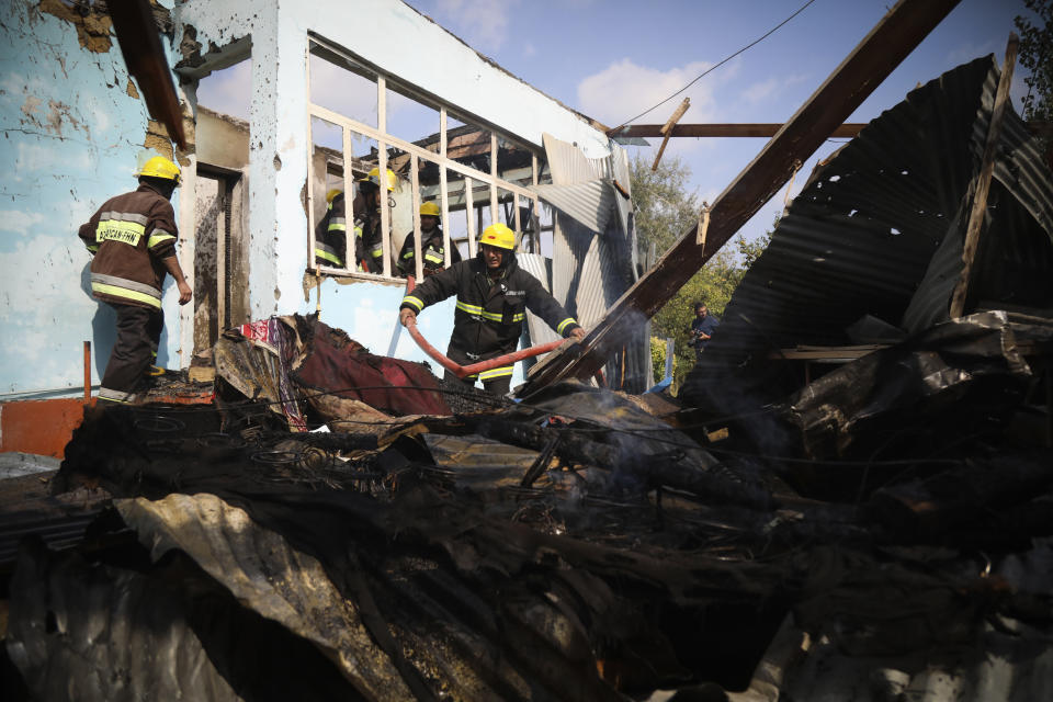 Azerbaijani firefighters work in damaged house after alleged recent shelling in a residential area in Agdam, Azerbaijan, on Thursday, Oct. 15, 2020. The conflict between Armenia and Azerbaijan is escalating, with both sides exchanging accusations and claims of attacks over the separatist territory of Nagorno-Karabakh. Heavy fighting is in a third week despite a cease-fire deal. (AP Photo/Aziz Karimov)