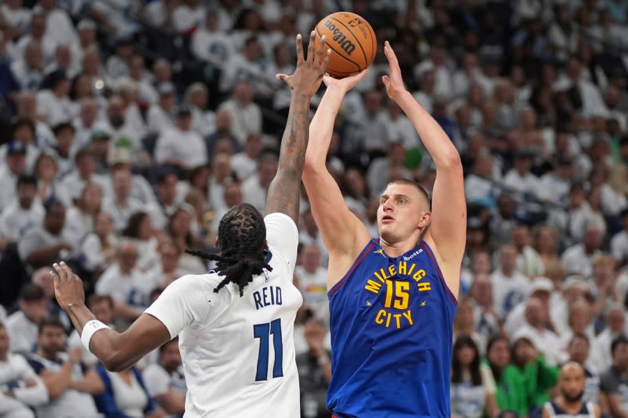 Denver Nuggets center Nikola Jokic (15) looks to shoot over Minnesota Timberwolves center <a class="link " href="https://sports.yahoo.com/nba/players/6253/" data-i13n="sec:content-canvas;subsec:anchor_text;elm:context_link" data-ylk="slk:Naz Reid;sec:content-canvas;subsec:anchor_text;elm:context_link;itc:0">Naz Reid</a> (11) during the first half of Game 3 of an NBA basketball second-round playoff series, Friday, May 10, 2024, in Minneapolis. (AP Photo/Abbie Parr)