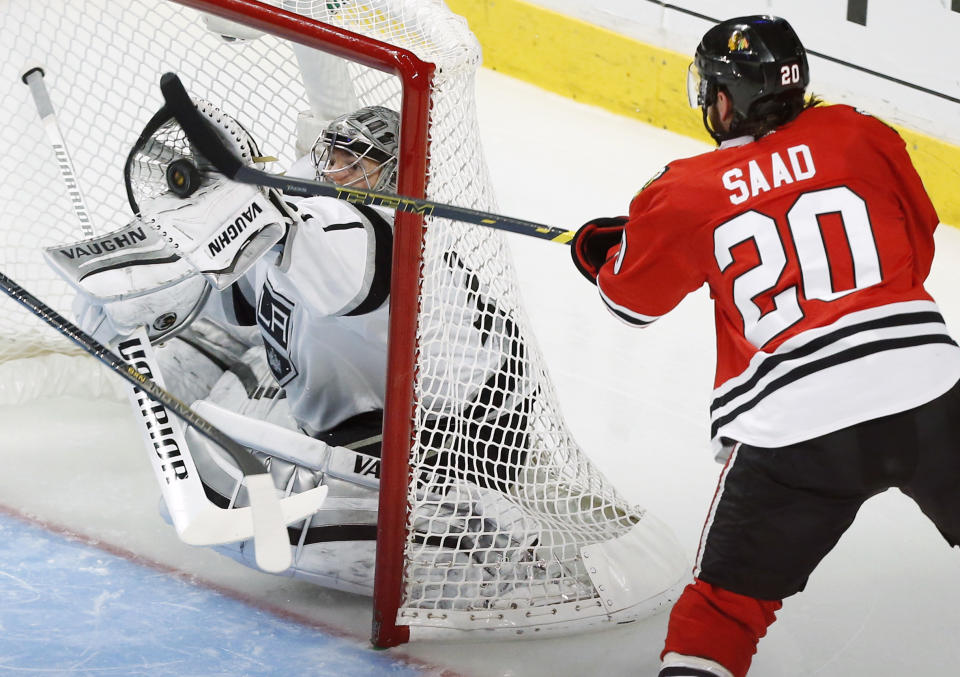 Los Angeles Kings goalie Jonathan Quick, left, saves a goal shot by Chicago Blackhawks left wing Brandon Saad (20) during the second period in Game 5 of the Western Conference finals in the NHL hockey Stanley Cup playoffs Wednesday, May 28, 2014, in Chicago. (AP Photo/Andrew A. Nelles)
