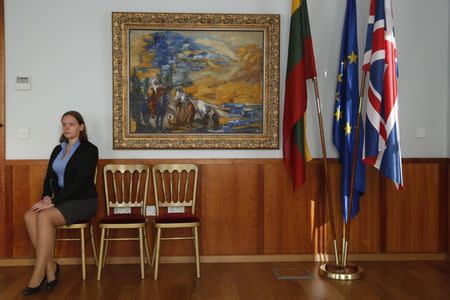 Embassy intern Leva Andrukaityte poses with the artwork "Landscape of Jerusalem with Bedouins" by artist Emmanuel Mane-Katz, at the Embassy of Lithuania in London December 8, 2014. REUTERS/Luke MacGregor