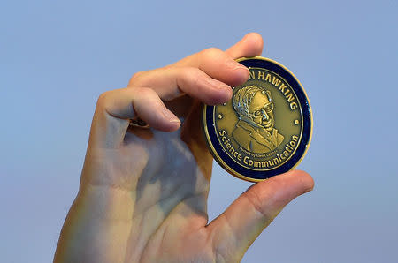 British musician and astrophysicist Brian May holds a medal as he attends a launch event for a new award for science communication, called the Stephen Hawking Medal for Science Communication, in London in Britain December 16, 2015. REUTERS/Toby Melville/Files