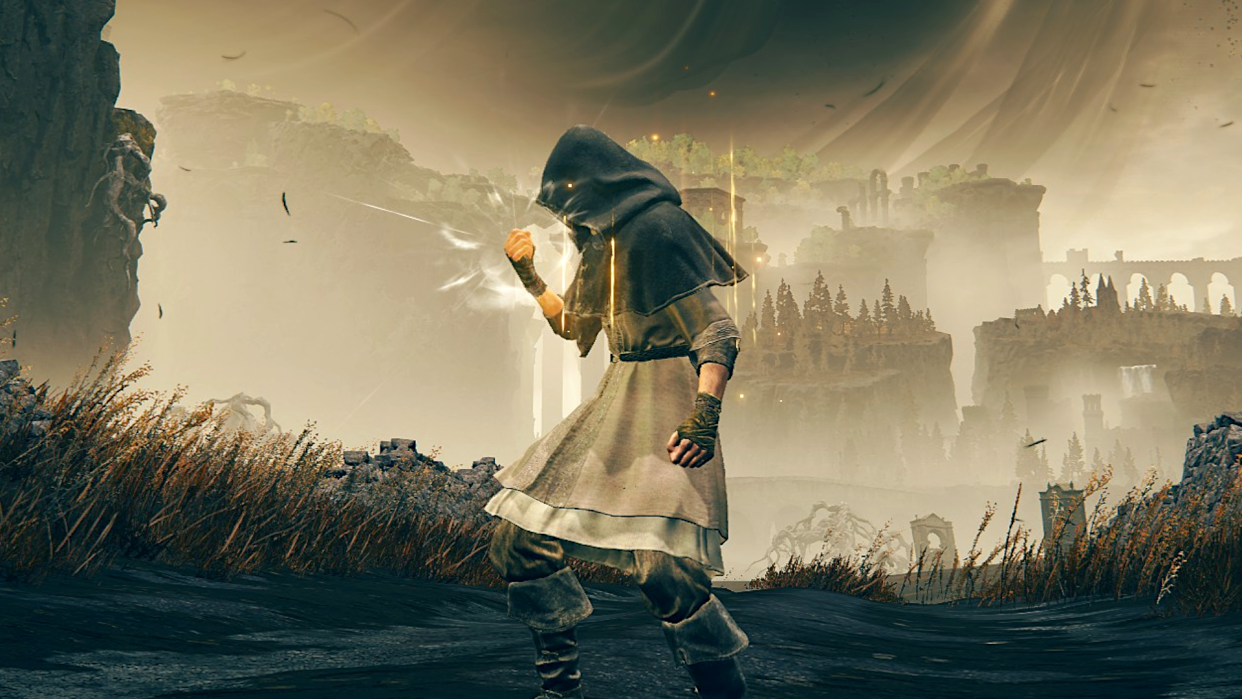  A character in Elden Ring: Shadow of the Erdtree stood in a field with elaborate ruins in the backdrop, clenching their fist as they charge up an attack. 