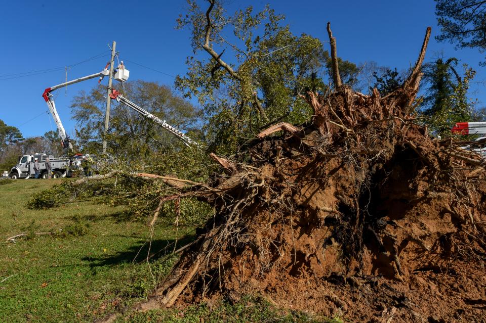 Nov 30, 2022; Eutaw, Alabama, USA;  in Eutaw, Ala., A line crew from Alabama Power works to restore downed power lines along Highway 14 in front of the Robert Brown Middle School in Eutaw after a small tornado hit the town located in Greene County Tuesday, Nov. 29, 2022. No injuries were reported from the storm.