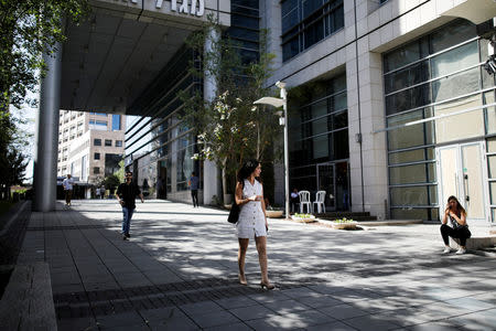 FILE PHOTO: A woman walks near high-rise buildings in the high-tech business area of Tel Aviv, Israel May 15, 2017. REUTERS/Amir Cohen/File Photo