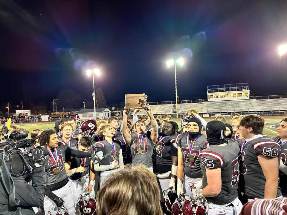 Junior Michael Gaul lifts the District 6 Class 6A title over his head to celebrate with his teammates after State College beat Altoona, 16-6, on Friday night at Hollidaysburg.