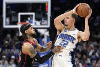 Orlando Magic's Franz Wagner (22) looks to pass the ball as Toronto Raptors' Gary Trent Jr. defends during the second half of an NBA basketball game Friday, Dec. 9, 2022, in Orlando, Fla. (AP Photo/John Raoux)