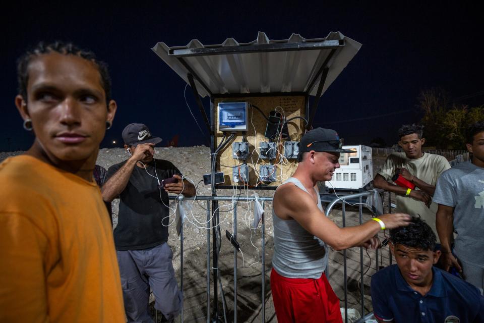 Migrants who wish to enter the U.S. in order to work, charge their phones at a shelter in the Ciudad Juárez, Mexico in late May, 2023.