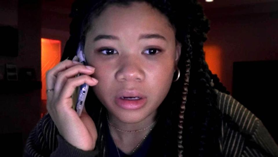 Storm Reid as june in missing movie talks on the phone with a concerned look on her face.