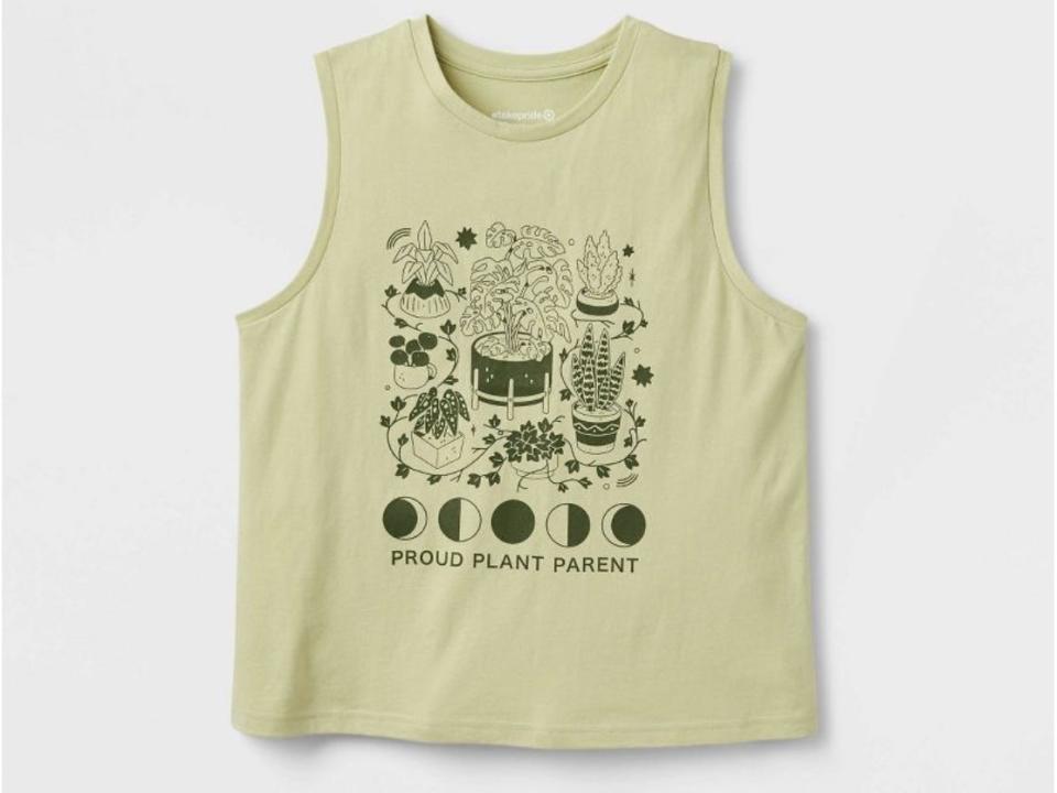 A light green tank on a white background. The tank has images of crystals, plants, and the phases of the moon. At the bottom of the shirt, it says "proud plant parent."