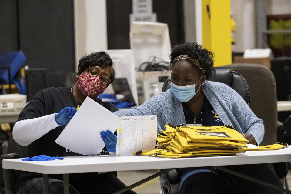 Trabajadores electorales revisan las tarjetas de memoria de las máquinas de votación que almacenan las papeletas, luego de la segunda vuelta de las elecciones al Senado, el martes 5 de enero de 2020, en Atlanta. (AP Foto/Ben Gray)