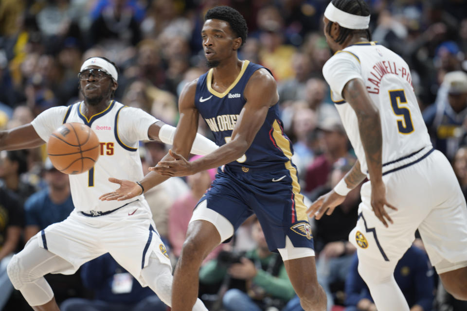 New Orleans Pelicans forward Herbert Jones, center, juggles the ball as Denver Nuggets guards Reggie Jackson, left, and Kentavious Caldwell-Pope defend in the first half of an NBA basketball game Monday, Nov. 6, 2023, in Denver. (AP Photo/David Zalubowski)