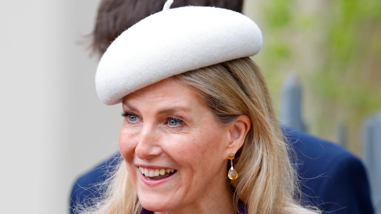 Sophie in grey beret and purple coat close up