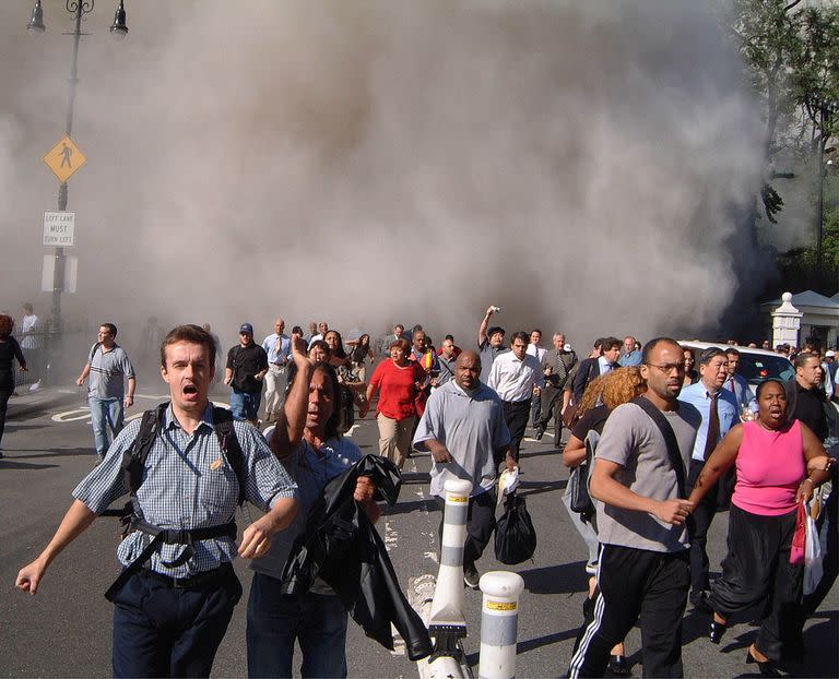 Los peatones luchan por ponerse a salvo frente al Ayuntamiento cuando la primera torre del World Trade Center se derrumba