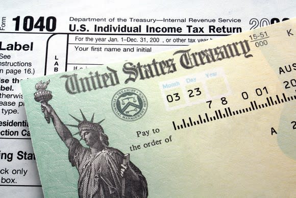 Federal income tax refund check sitting atop IRS Form 1040. 