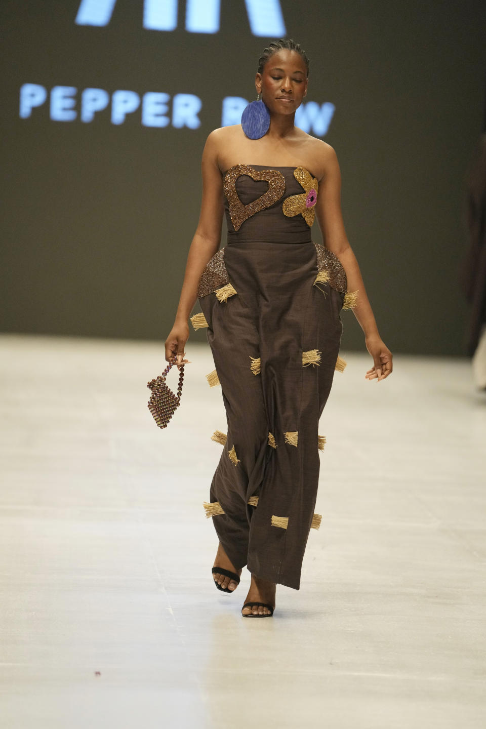 A model wears a creation by Pepper Row during the Lagos Fashion Week in Lagos, Nigeria, Thursday, Oct. 26, 2023. Africa's fashion industry is rapidly growing to meet local and international demands but a lack of adequate investment still limits its full potential, UNESCO said Thursday in its new report released at this year's Lagos Fashion Week show. (AP Photo/Sunday Alamba)