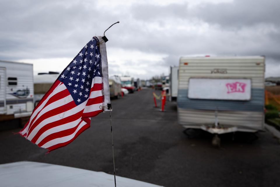 A flag flutters on the antenna of a vehicle at a campsite in west Eugene on March 28, 2023.