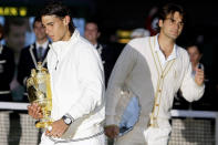 FILE - In this Sunday, July 6, 2008, file photo, Spain's Rafael Nadal left, walks with his trophy past Switzerland's Roger Federer after winning the men's singles final on the Centre Court at Wimbledon. (AP Photo/Anja Niedringhaus, File)
