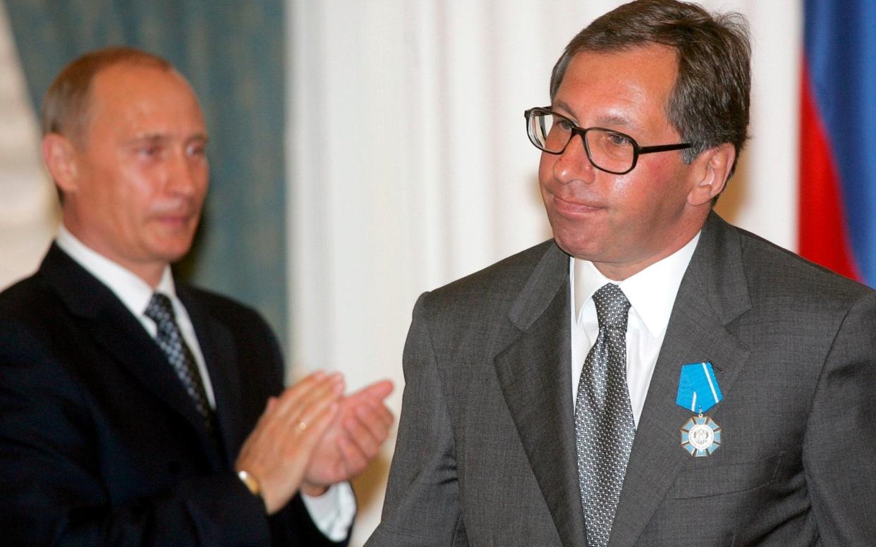 Russian President Vladimir Putin applauds then Alfa-Bank head Petr Aven after awarding him with the Order of Merit to the Fatherland during a ceremony at the Kremlin in 2005 - AFP