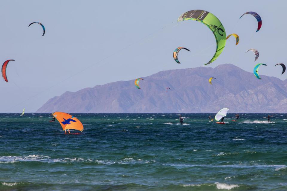 Kite surfers ride through the splashing water