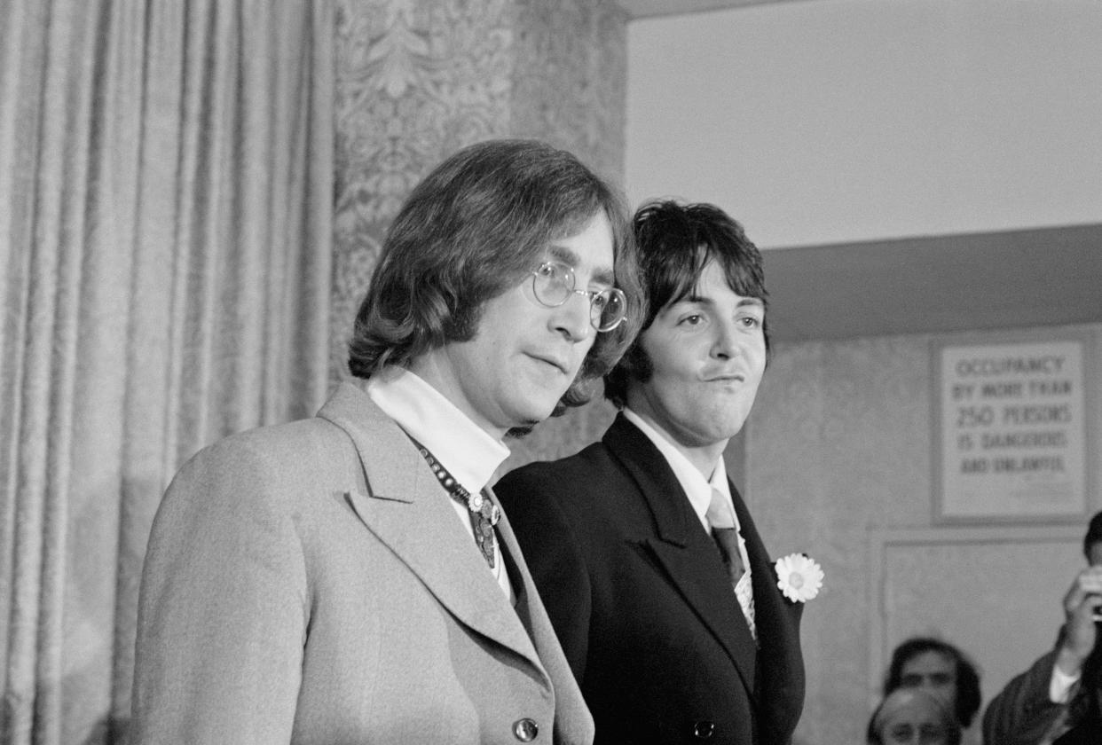 (Original Caption) Beatle business...Beatles John Lennon (left) and Paul McCartney face the press here, May 14th, and announce the establishment of an organization to serve as a catchall of the entertainment business. The British quartet has transformed its Beatles Ltd. into Apple Corps, Ltd., which has purchased, for $1.5 million an 18th century building on Savile Row to serve as headquarters for projects in films, electronics, recordings and merchandising. In their usual glib way, the two gave vague answers to newsmen's questions. "We don't know anything about business. We've hired people for that," was one example.