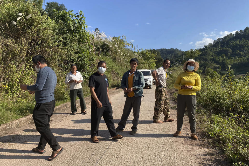 A group claiming to be local villagers use vehicles to block the roads leading to a mineshaft near Danaoshan in southern China's Yunnan province on Tuesday, Dec. 1, 2020. The mine shaft once harbored bats infected with the closest known relative of the COVID-19 virus. (AP Photo/Ng Han Guan)