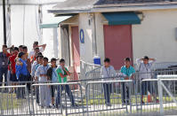 Children line up to enter a tent at the Homestead Temporary Shelter for Unaccompanied Children, Tuesday, Feb. 19, 2019, in Homestead, Fla. (AP Photo/Wilfredo Lee)