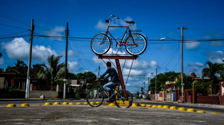 A Cuban rides his bike past a bicycle monument in Cardenas, a city 130 km east of Havana