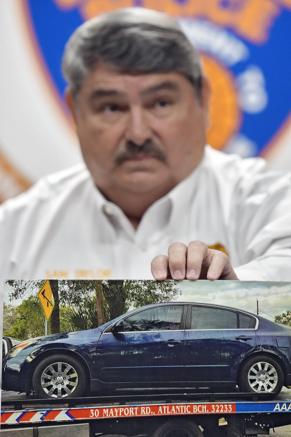 Lakeland Police Chief Sam Taylor holds up a photo of the suspect's car that was involved in a shooting Tuesday, Jan. 31, 2023, in Lakeland, Fla. Police say several people were shot and wounded during a drive-by shooting in a central Florida neighborhood. (AP Photo/Chris O'Meara)