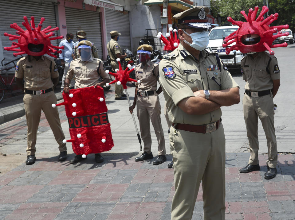 Indian policemen wearing virus themed helmets wait to interact with people during an awareness drive aimed at preventing the spread of the coronavirus in Hyderabad, India, Thursday, May 27, 2021. (AP Photo/Mahesh Kumar A.)