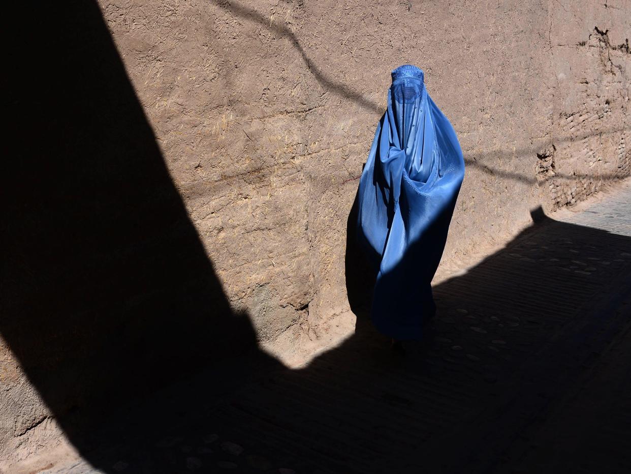 A burqa-clad Afghan woman walks through the old quarters of Herat.