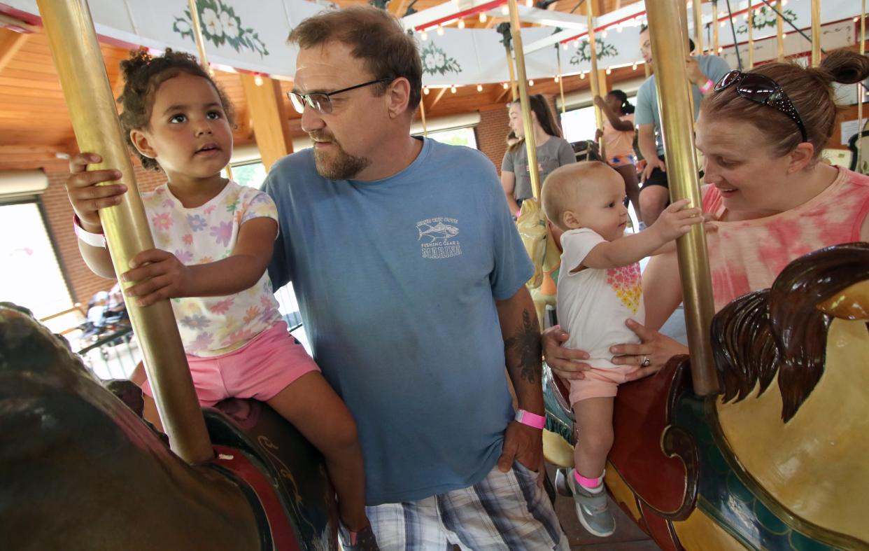 Two-year-old Madelyn and 1-year-old Makenna ride the carousel with help from their parents, Travis and Pate Emery, during the 2024 Foothill's Merry-Go-Round Festival held Saturday, April 27, 2024, at the Shelby City Park.
