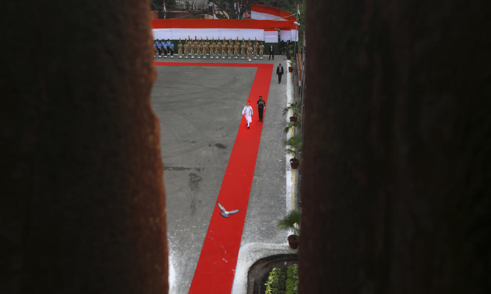 In this Wednesday, Aug. 15, 2018, photo, a bird flies past as Indian Prime Minister Narendra Modi, in white, arrives at the historical Red Fort to address the nation on the country's Independence Day, in New Delhi, India. India won independence from British colonialists in 1947. (AP Photo/Manish Swarup, File)