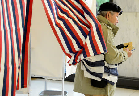 A French citizen living in the United States leaves a voting booth after casting his ballots in the French presidential run-off between Emmanuel Macron and Marine Le Pen, at the French Embassy in Washington, U.S., May 6, 2017. REUTERS/Mike Theiler