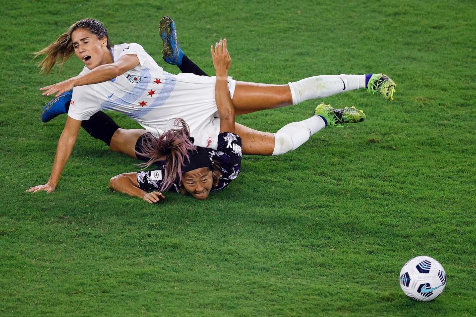 Yuki Nagasato of Racing Louisville and Katie Johnson of the Chicago Red Stars battle for a ball during an NWSL game.