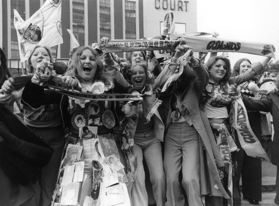 28th May 1975:  Excited female Osmond fans wait outside Earls Court exhibition hall in London, where their pop idols will perform later that evening (Getty Images)