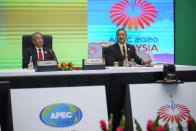 Malaysia's Prime Minister Muhyiddin Yassin, left, and Foreign Minister Hishammuddin Hussein wait for their opening remarks of the first virtual Asia-Pacific Economic Cooperation (APEC) leaders' summit, hosted by Malaysia, in Kuala Lumpur, Malaysia, Friday, Nov. 20, 2020. (AP Photo/Vincent Thian)