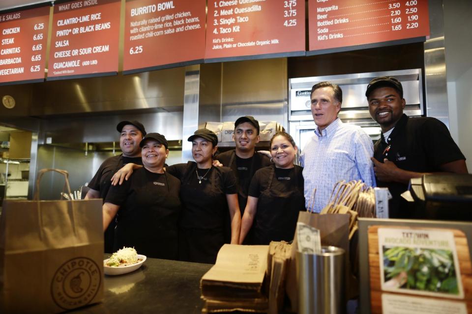 Republican presidential candidate, former Massachusetts Gov. Mitt Romney takes a photo with workers as he makes an unscheduled stop at a Chipotle restaurant in Denver, Tuesday, Oct. 2, 2012. (AP Photo/Charles Dharapak)